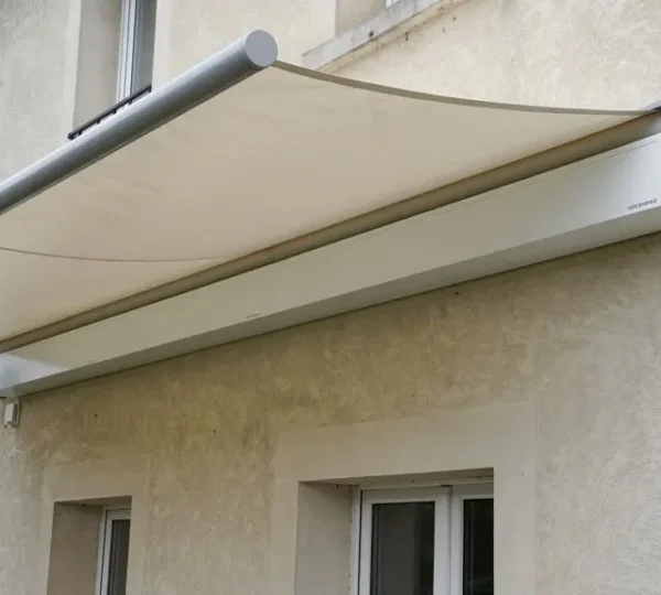 Store banne de 6 mètres déployé sur une façade résidentielle montrant l'encombrement complet du coffre et de la toile